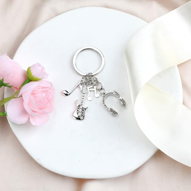 Detalle de Edelstahl-Schlüsselanhänger für Musikliebhaber mit Gitarre, Kopfhörern und Noten