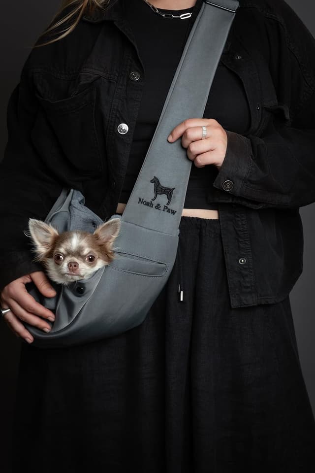 Detalle de Noah & Paw dog sling carrier (3–10lb) with adjustable padded strap, lined twill and double safety