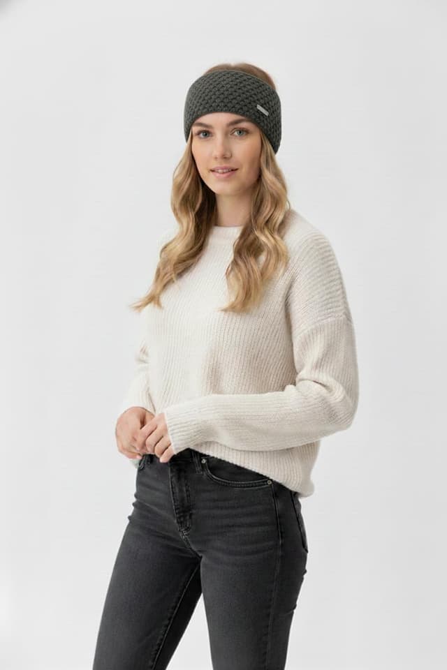 Detalle de Eisglut Stirnband Minal Merino in Oliv: warm, weich und mit dezentem Emblem