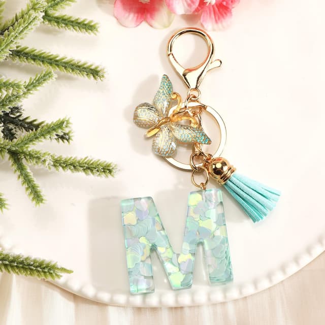 Detalle de OBEISN Buchstaben-Schlüsselanhänger mit Schmetterling & Quasten – kreativer Anhänger für Frauen