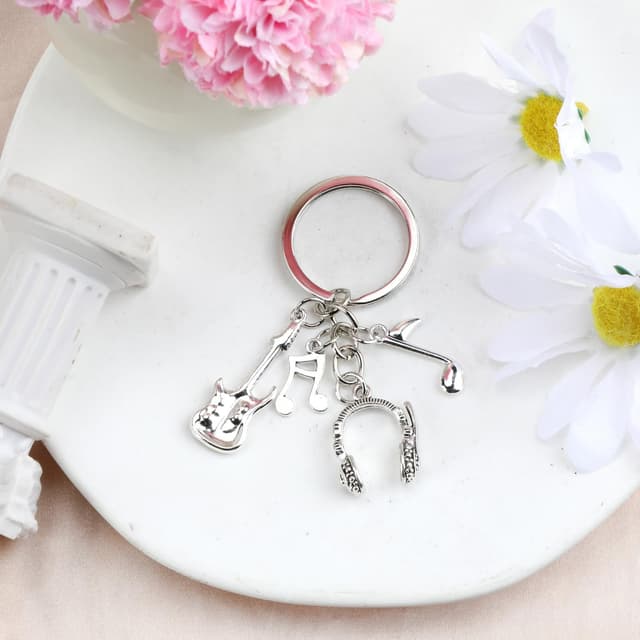 Detalle 2 de Edelstahl-Schlüsselanhänger für Musikliebhaber mit Gitarre, Kopfhörern und Noten