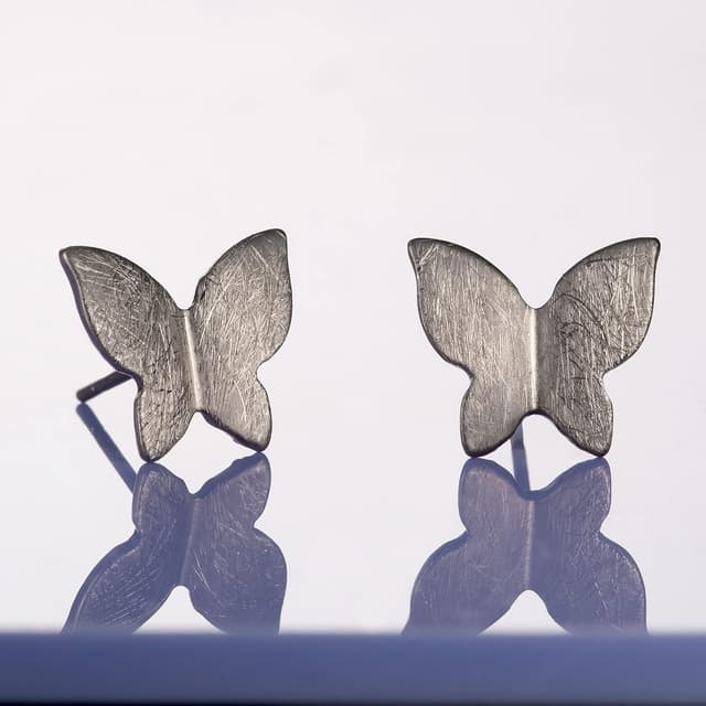 Detalle 2 de Boucles d’oreilles papillon Namana (puces) avec finition brossée et écrin cadeau