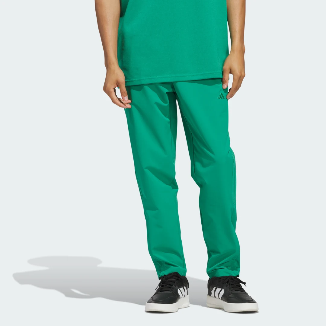 Detalle de Woven Track Pants de Adidas: pantalón deportivo en verde para entrenar y descansar