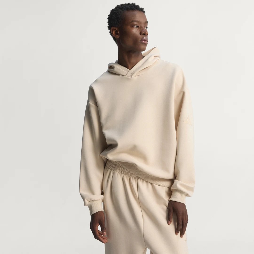 Detalle de SUDADERA CON CAPUCHA SOFT LUX de Adidas: comodidad suave y estilo minimalista en beige