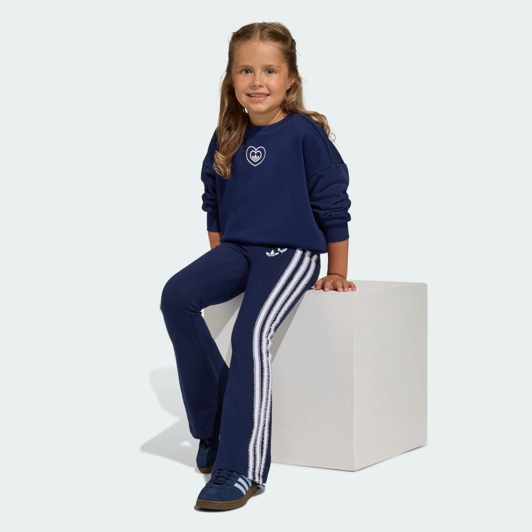 Detalle de Conjunto con mallas acampanadas Adidas Disney Crew: lujo cómodo para fans y streetwear
