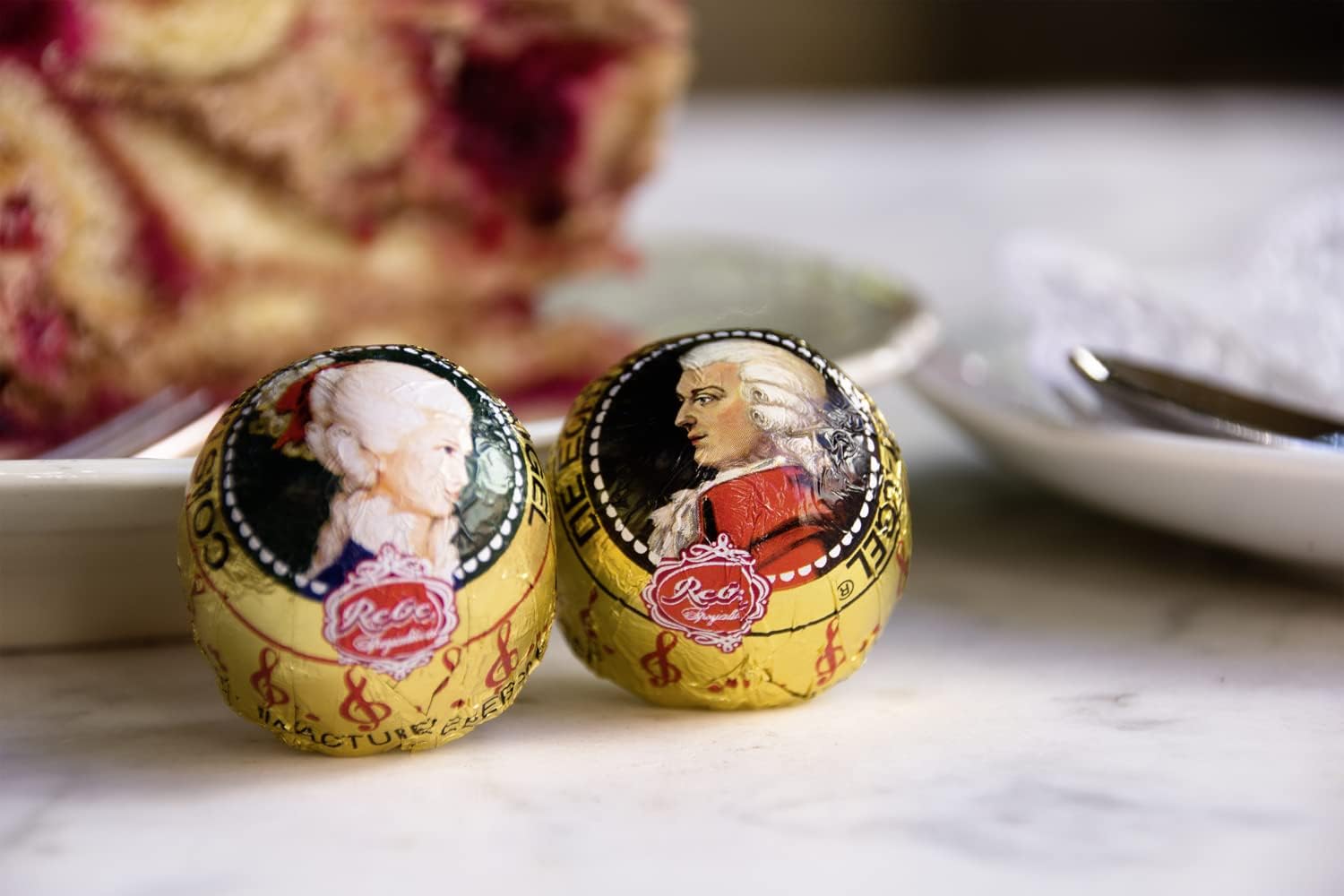 Detalle de Reber Mozart-Kugeln Barock – 12er Packung, Zartbitter-Schokolade mit Pistazien-Marzipan, Mandeln und Haselnuss-Nougat (240 g)