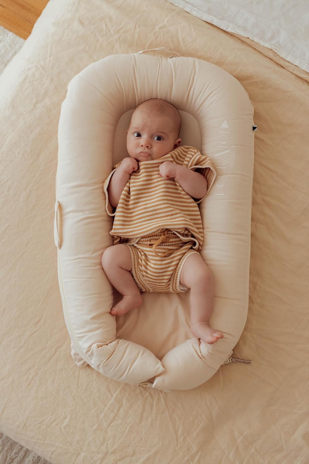 Detalle de DockATot Deluxe+ Dock - Sand Chambray: A practical lounge and play spot for babies