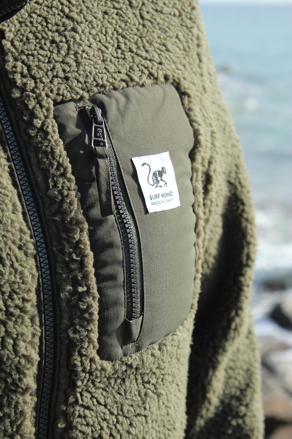 Detalle de Surf Monkey Veste Sherpa en polaire recyclée – zip intégral, poche poitrine et coupe classique
