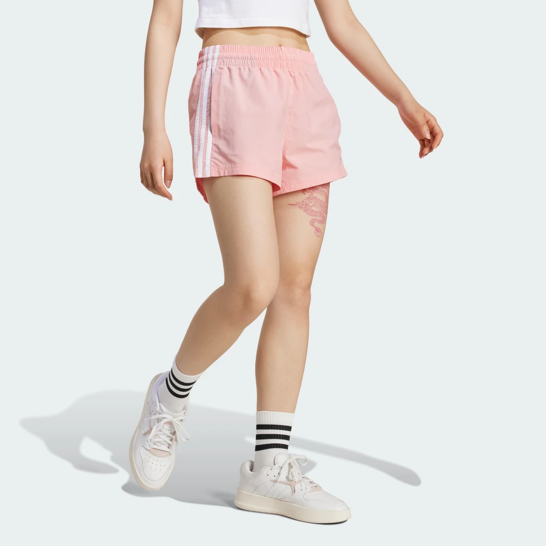Detalle de Pantalón corto Essentials Woven 3 bandas de Adidas (rosa): guía de compra